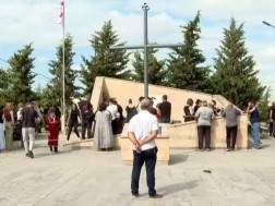 Family members and citizens gather at the memorial of the heroes who died in the village of Shindisi